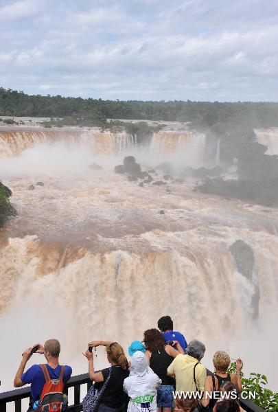 People visit the Iguazu Falls in Foz do Iguazu at the southern border of Brazil, Feb. 15, 2011. Due to recent heavy rains, the flow of the Iguazu Falls increased from 1,500 cubic meters per second to 6,500 cubic meters per second.