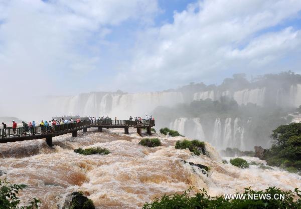 People visit the Iguazu Falls in Foz do Iguazu at the southern border of Brazil, Feb. 15, 2011. Due to recent heavy rains, the flow of the Iguazu Falls increased from 1,500 cubic meters per second to 6,500 cubic meters per second.