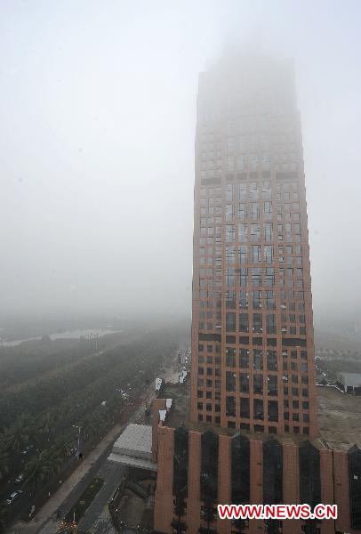 The photo taken on Feb. 17, 2011 shows an aerial view of fog-shrouded Haikou in Hainan Province, south China. A &apos;yellow&apos; fog alert was issued in Haikou on Thursday. China has a color-coded weather warning system: red, orange, yellow and blue. Blue is the least serious level. [Xinhua] 