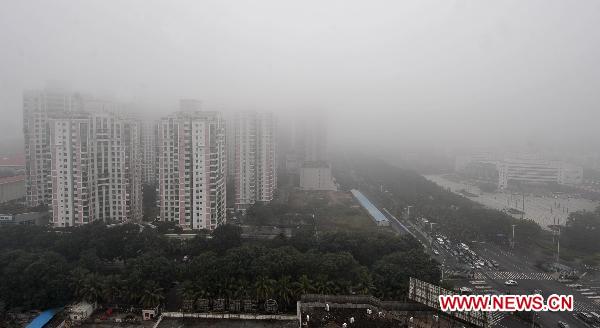 Buildings are seen amid fog in Haikou, capital of south China&apos;s Hainan Province, Feb. 17, 2011. A &apos;yellow&apos; fog alert was issued in Haikou on Thursday. China has a color-coded weather warning system: red, orange, yellow and blue. Blue is the least serious level.