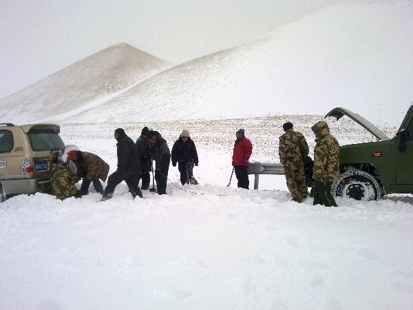 Rescuers tie a tow cable to pull a stranded vehicle out of snow on a crucial national road link in Ali Prefecture, southwest China&apos;s Tibet Autonomous Region, Feb. 16, 2011. Heavy snowfalls have hit the region since Sunday and paralyzed the traffic along the Xinjiang-Tibet Highway. Rescue teams equipped with heavy vehicles were sent out to transfer snowbound travelers and clean snow from roads.