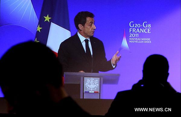 People watch French President Nicolas Sarkozy delivering a keynote speech through a TV screen at the G20 press center in Paris, France, Feb. 18, 2011. The 2-day G20 meeting of Finance Ministers and Central Bank Governors opened here on Friday. 