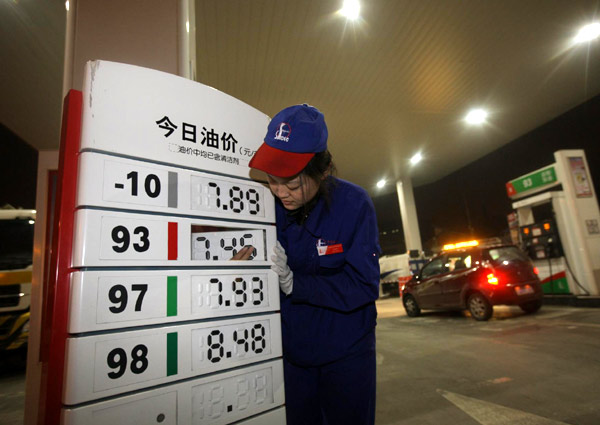 A worker adjusts the price tag at a gas station in Beijing, Feb 20, 2011.[Xinhua]
