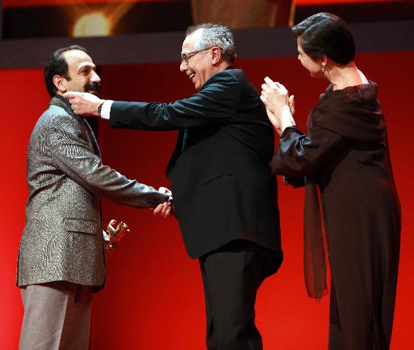 Iranian Director Asghar Farhadi (L) is awarded with the Golden bear for 'Best film' for the movie 'Jodaeiye Nader az Simin' (Nader And Simin, A Separation) by Berlinale Film Festival director Dieter Kosslick (C) and Italian actress and jury president Isabella Rossellini during the awards ceremony at the 61st Berlinale International Film Festival in Berlin, Feb. 19, 2011. [Xinhua] 