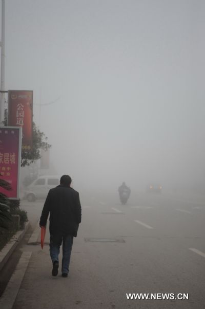 A man walks on the fog shrouded street in Shangrao, east China&apos;s Jiangxi Province, Feb. 20, 2011. Shangrao witnessed heavy fog on Sunday. [Xinhua]