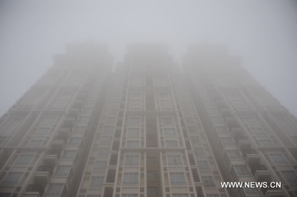 Photo taken on Feb. 20, 2011 shows a building in heavy fog in Shangrao, east China&apos;s Jiangxi Province, Feb. 20, 2011. Shangrao witnessed heavy fog on Sunday. [Xinhua] 