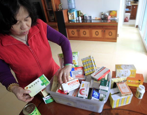 A woman checks her family's reserve stock of medicines in her house in Guangzhou, capital of Guangdong province, on Sunday. 