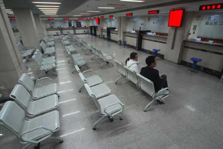 Only two people sit in a real estate trading center in Nanjing Sunday, as the number of deals have dropped significantly since new rules were announced.[CFP]