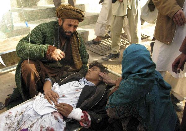 A mother touches her wounded son after a suicide attack in Emam Saheb district of Kunduz province February 21, 2011. [Xinhua]