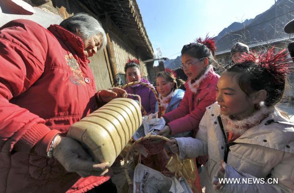 Young girls visit their neighbors to collect Spring Festival leftovers in Yangshudixia Village of Beijing, capital of China, Feb. 18, 2011. 