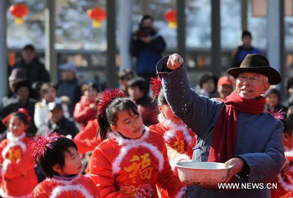 A man imitates feeding sparrows, a tradition during the Lianqiao Festival in Yangshudixia Village of Beijing, capital of China, Feb. 17, 2011.