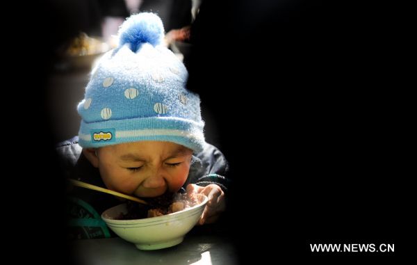 A boy gorges at the fete to celebrate the Lianqiao Festival in Yangshudixia Village of Beijing, capital of China, Feb. 17, 2011.