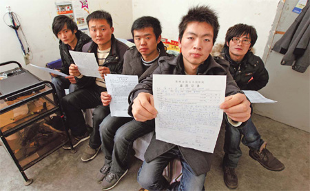 Five men affected by exposure to the chemical n-hexane at an Apple supplier factory in Suzhou, Jiangsu province, display the hospital discharge papers they received following treatment. From left are Sang Xiaolong, Jia Jingchuan, Yao Xiaoping, Zhang Fei and Hu Zhiyong. 