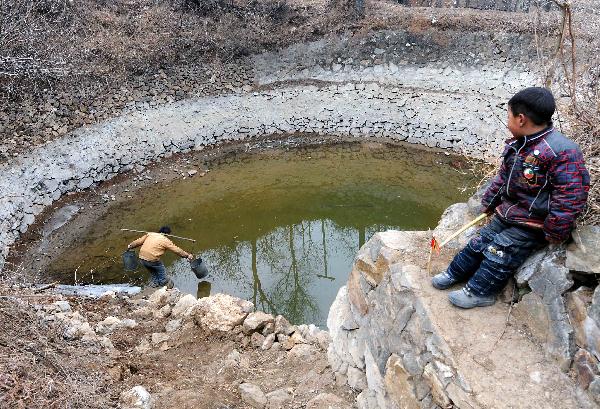 A villager collects water from a pond to be dried up in Jiangling Village, Song County of central China&apos;s Henan Province, Feb. 22, 2011. Suffering from the most serious drought within 50 years, Henan Province has no effective rainfall for more than 130 days, with 29 million mu (1.94 million hectare) paddy fields and drinking water in some mountainous regions affected. [Xinhua] 
