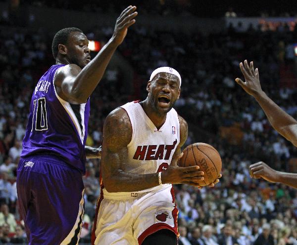 Miami Heat's LeBron James (R) grimaces as he is fouled by Sacramento Kings Samuel Dalembert during first quarter in NBA basketball action in Miami, Florida February 22, 2011. (Xinhua/Reuters Photo)