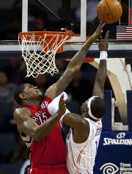 Toronto Raptors power forward Amir Johnson (L) blocks a shot by Charlotte Bobcats shooting guard Stephen Jackson during an NBA basketball game in Charlotte, North Carolina February 22, 2011. (Xinhua/Reuters Photo) 