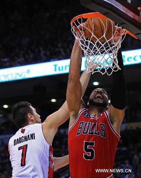 Carlos Boozer (R) of Chicago Bulls dunks the ball during the NBA game against Toronto Raptors at Air Canada Centre in Toronto, Canada, Feb.23, 2011. Raptors won 118-113. (Xinhua/Zou Zheng) 