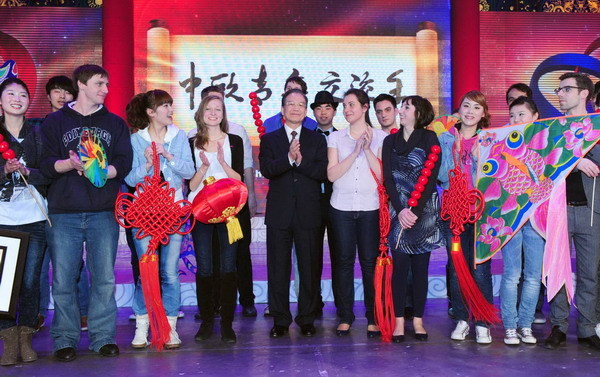 Chinese Premier Wen Jiabao stands with young people from both China and Europe at the opening ceremony of the China-EU Year of Youth in Beijing Feb 23, 2011. [Photo/Xinhua] 