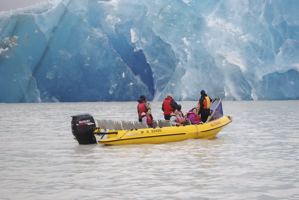 Tourists on a boat watch an iceberg, broken off from the glacier after Tuesday's earthquake, in the Tasman Lake, 200km (124 miles) southeast of Christchurch in this handout photograph released Feb 23, 2011. [Agencies] 