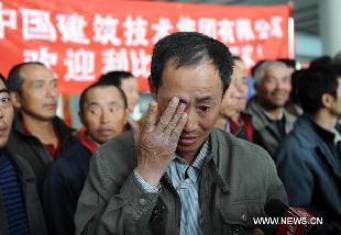 Chinese worker Dai Huidong weeps as he reminds of the experience in Libya at the Beijing Capital International Airport in Beijing, capital of China, Feb. 24, 2011. The first group of 43 Chinese evacuated from riot-torn Libya arrived in Beijing Thursday morning on a flight from Egypt's northern city of Alexandria. [Jin Liangkuai/Xinhua]
