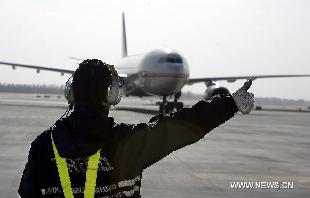 The plane carrying Chinese workers lands on the tarmac at the Beijing Capital International Airport in Beijing, capital of China, Feb. 24, 2011. The first group of 43 Chinese evacuated from riot-torn Libya arrived in Beijing Thursday morning on a flight from Egypt's northern city of Alexandria. [Jing Lei/Xinhua]