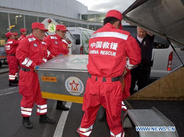 Chinese rescue team members carry relief materials upon their arrival at an airport in Auckland, New Zealand, on Feb. 25, 2011. The 10-member Chinese rescue team, including experts and rescuers, arrived in Auckland on Friday and head for the quake area in Christchurch by New Zealand's military aircraft. [Li Yaoyu/Xinhua]