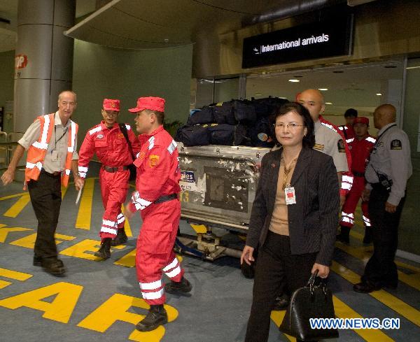 Liao Juhua (R, Front), Chinese Consul General to Auckland, accompanies Chinese rescue team members to walk out of an airport in Auckland, New Zealand, on Feb. 25, 2011. The 10-member Chinese rescue team, including experts and rescuers, arrived in Auckland on Friday and head for the quake area in Christchurch by New Zealand's military aircraft. [Li Yaoyu/Xinhua]