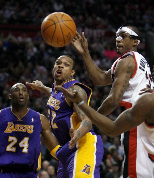 Portland Trail Blazers center Dante Cunningham (R) reaches for a rebound against Los Angeles Lakers defenders Kobe Bryant (L) and Shannon Brown (C) during the first quarter of their NBA basketball game in Portland, Oregon February 23, 2011. (Xinhua/Reuters Photo)