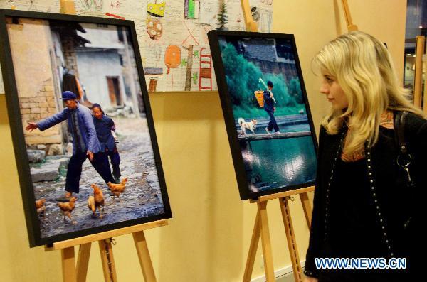 A visitor watches the photos displayed at the 'China Story' photo exhibition held at the headquarters of European Commission in Brussels, Belgium, Feb. 24, 2011. The two-week 'China Story' photo exhibition displayed 64 photos by Chinese photographer Zhao Hui in Brussels.