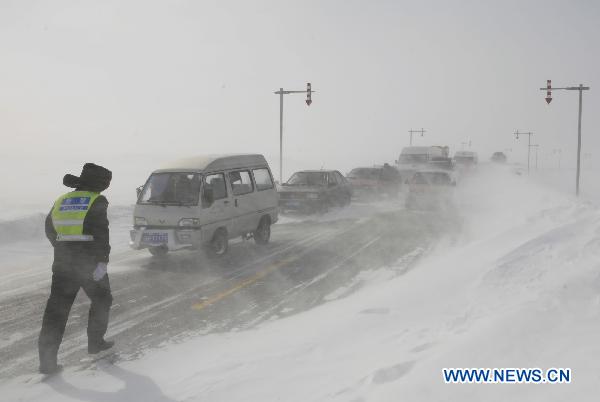 A policeman rescues stranded vehicles on the No. 217 national highway in Altay, northwest China&apos;s Xinjiang Uygur Autonomous Region, Feb. 24, 2011. (
