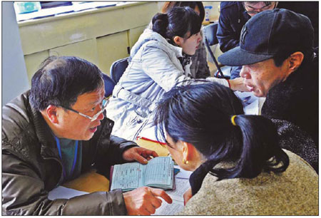A staff member with the Shanghai Luwan district government talks to people applying for affordable housing on Saturday. The interview is the start of the application process. [Photo/Xinhua] 