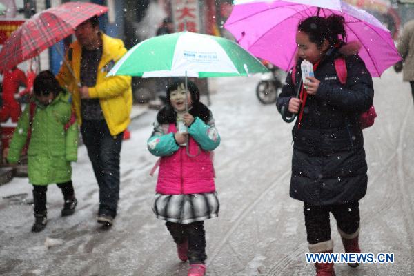 Citizens walk in snow in Bozhou, east China&apos;s Anhui Province, Feb. 28, 2011. The snowfall in the city Monday is said in favor of spring farming. [Xinhua] 