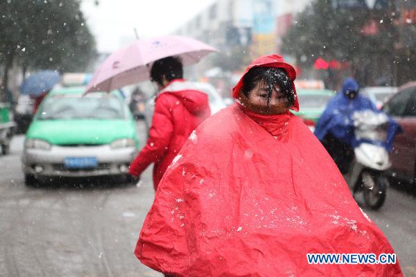 A citizen rides in snow in Bozhou, east China&apos;s Anhui Province, Feb. 28, 2011. The snowfall in the city Monday is said in favor of spring farming. 