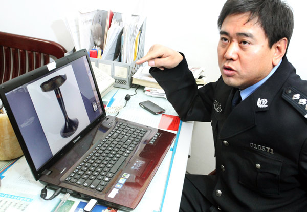 Han Qinglong, head officer of the Heritage Inspection Team under the Xi'an Public Security Bureau, shows a cultural relic that was retrieved from the hands of tomb robbers, on Jan 11.