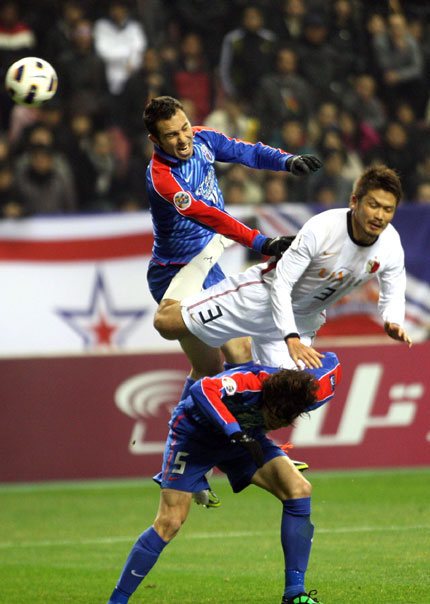 Abdulkader Dakka (left) of Shanghai Shenhua competes for a header with Daiki Iwamasa of Kashima Antlers during their AFC Champions League Group H match at Hongkou Football Stadium in Shanghai last night. The match ended goalless.  