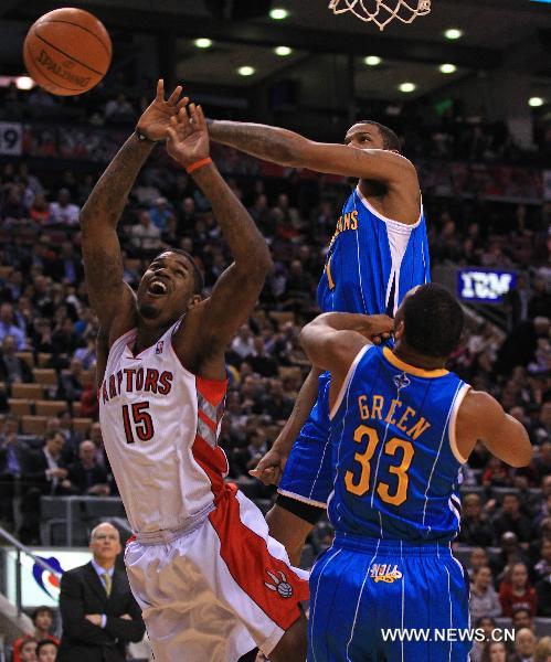 Trevor Ariza (2nd R) of New Orleans Hornets blocks Amir Johnson (L) of Toronto Raptors during their NBA game at Air Canada Centre in Toronto, Canada, March 1, 2011. Raptors won 96-90.(Xinhua/Zou Zheng) 