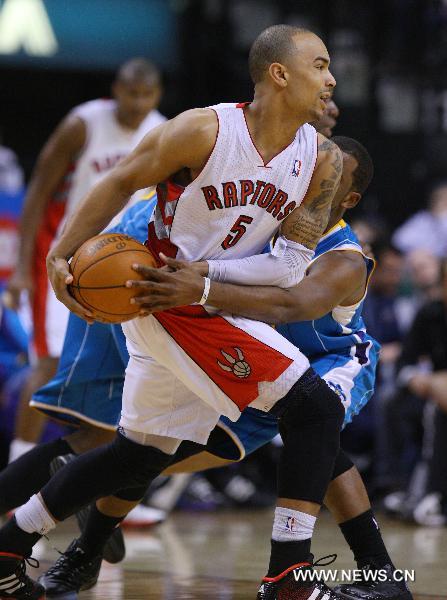 Jerryd Bayless (Front) of Toronto Raptors tires to pass the ball during the NBA game against New Orleans Hornets at Air Canada Centre in Toronto, Canada, March 1, 2011. Raptors won 96-90.(Xinhua/Zou Zheng) 