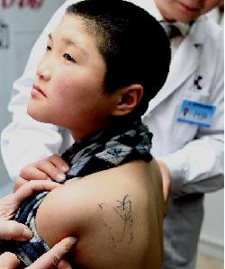 Help for tattooed beggar boy.[Sina.com]