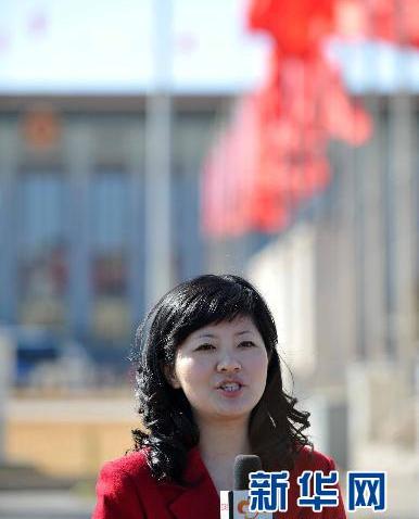 A journalist from Wuhan TV Station stands in front of the Great Hall of the People to cover the 4th Session of 11th CPPCC on March. 3 2011. [Xinhua]