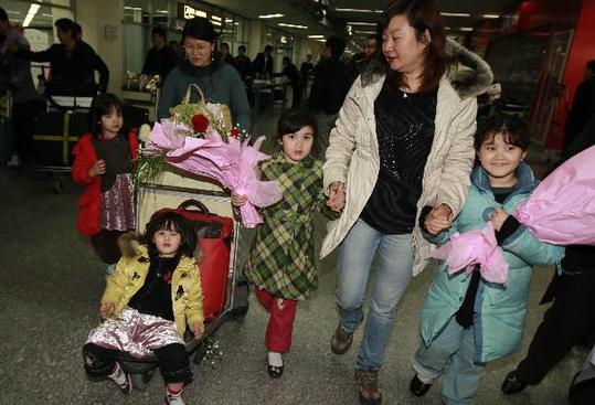 Zhang Chunyan (L, back) and her four daughters exit Hongqiao International Airport upon arrivals in east China's Shanghai on March 5, 2011. 