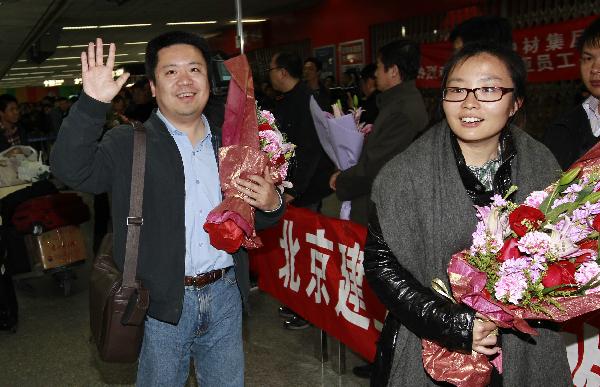 Bai Ning (L) exits Hongqiao International Airport with his colleagues upon arrivals in east China's Shanghai, March 5, 2011.