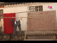 Buddhist temples exist alongside people's homes and shops. Here, one resident has hung clothes to dry outside the entrance to Huacheng Temple. [by Johanna Yueh/China.org.cn]
