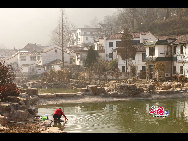 A villager washes clothes in a pond. [by Johanna Yueh/China.org.cn] 
