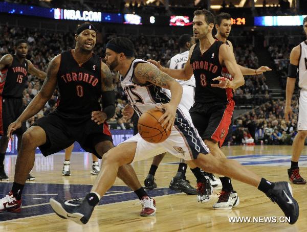 Deron Williams (C) of New Jersey Nets dribbles past James Johnson (L) and Jose Calderon of Toronto Raptors during a NBA game between New Jersey Nets and Toronto Raptors at the O2 Arena in London, Britain, March 5, 2011. Nets beat Raptors here on Saturday by 137:136 after three overtimes, in the second match of the first NBA regular-season games held in Europe. (Xinhua/Zeng Yi)