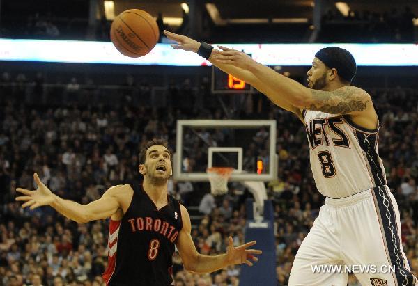 Deron Williams (R) of New Jersey Nets passes the ball during a NBA game between New Jersey Nets and Toronto Raptors at the O2 Arena in London, Britain, March 5, 2011. Nets beat Raptors here on Saturday by 137:136 after three overtimes, in the second match of the first NBA regular-season games held in Europe. (Xinhua/Zeng Yi)