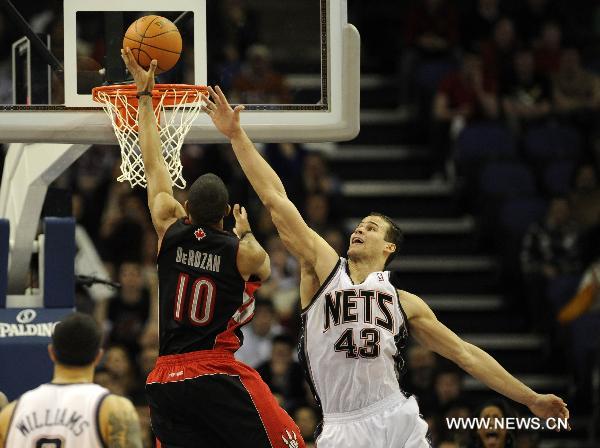 Kris Humphries (R) of New Jersey Nets tries to block DeMar DeRozan of Toronto Raptors during a NBA game between New Jersey Nets and Toronto Raptors at the O2 Arena in London, Britain, March 5, 2011. Nets beat Raptors here on Saturday by 137:136 after three overtimes, in the second match of the first NBA regular-season games held in Europe. (Xinhua/Zeng Yi)