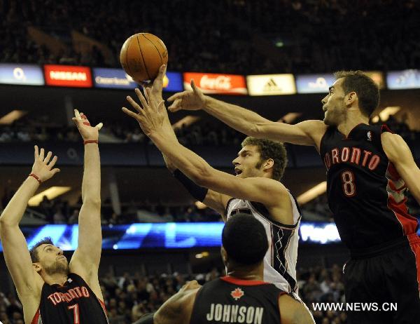 Brook Lopez (2nd R) of New Jersey Nets attempts a shot during a NBA game between New Jersey Nets and Toronto Raptors at the O2 Arena in London, Britain, March 5, 2011. Nets beat Raptors here on Saturday by 137:136 after three overtimes, in the second match of the first NBA regular-season games held in Europe. (Xinhua/Zeng Yi)