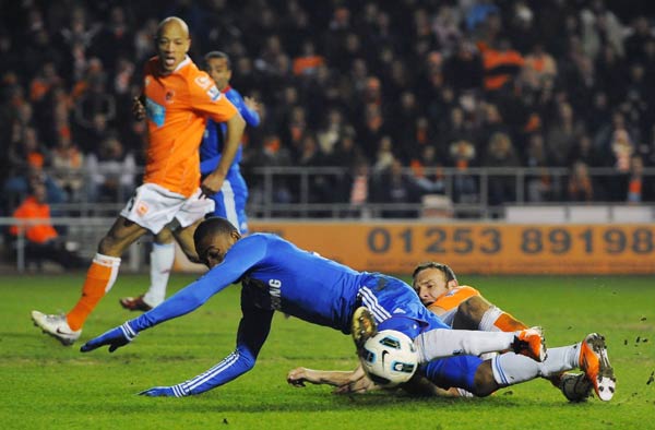 Blackpool's Ian Evatt (R) brings down Chelsea's Salomon Kalou (C) to concede a penalty during their English Premier League soccer match in Blackpool, northern England March 7, 2011.Two goals from Frank Lampard and another from John Terry gave Chelsea a 3-1 win at Blackpool on Monday to renew its hopes of retaining the Premier League title. (Xinhua/Reuters Photo) 