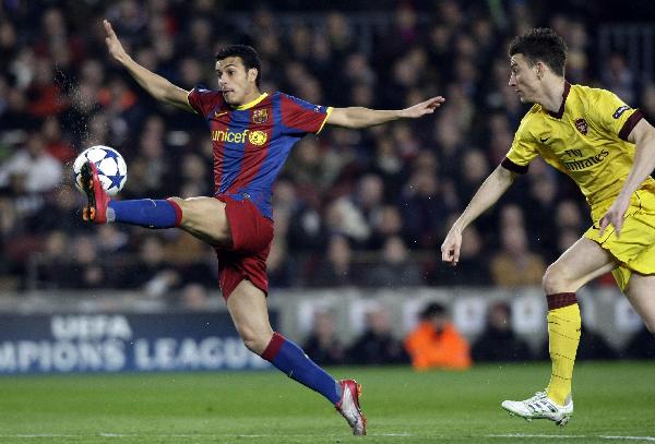 Barcelona's Pedro (L) controls the ball challenged by Arsenal's Laurent Koscielny during their Champions League soccer match at Nou Camp stadium in Barcelona March 8, 2011. (Xinhua/Reuters Photo)