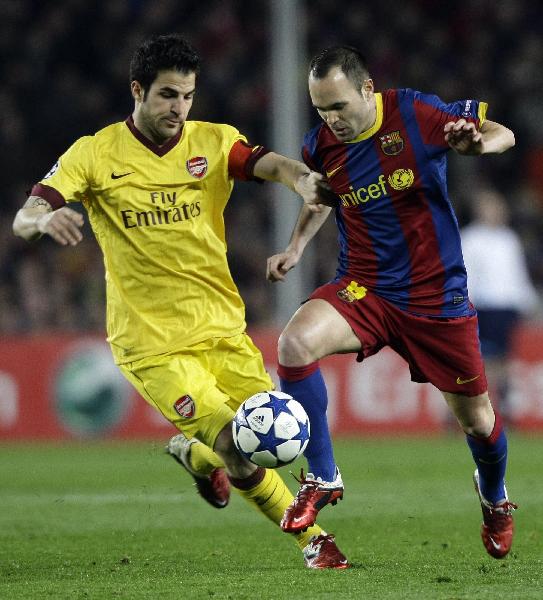 Barcelona's Andres Iniesta (L) fights for the ball with Arsenal's Jack Wilshere during their Champions League soccer match at Nou Camp stadium in Barcelona March 8, 2011. (Xinhua/Reuters Photo)